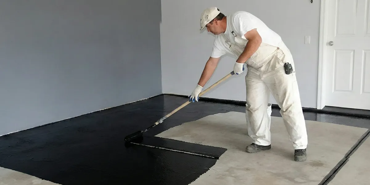 basement waterproofing professional applying waterproof coating to protect a basement floor in New Orleans, LA