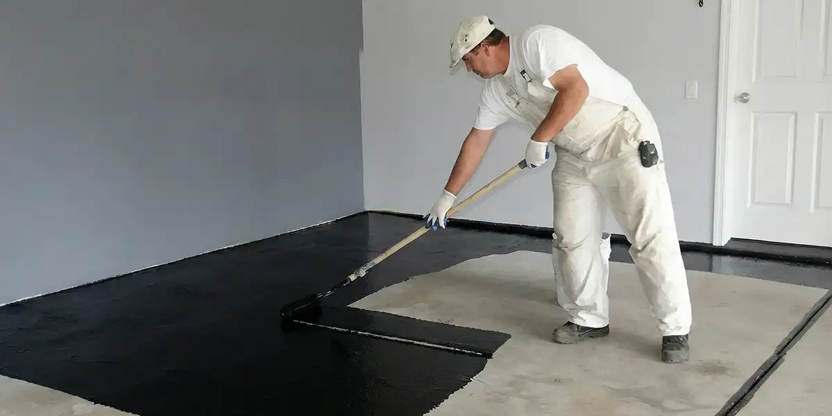 basement waterproofing professional applying waterproof coating to protect a basement floor in New Orleans, LA